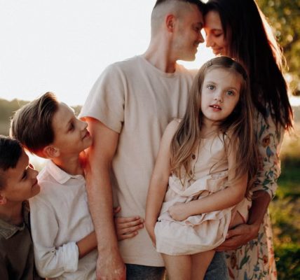 Family enjoying quality time together outdoors by the lake during sunset.